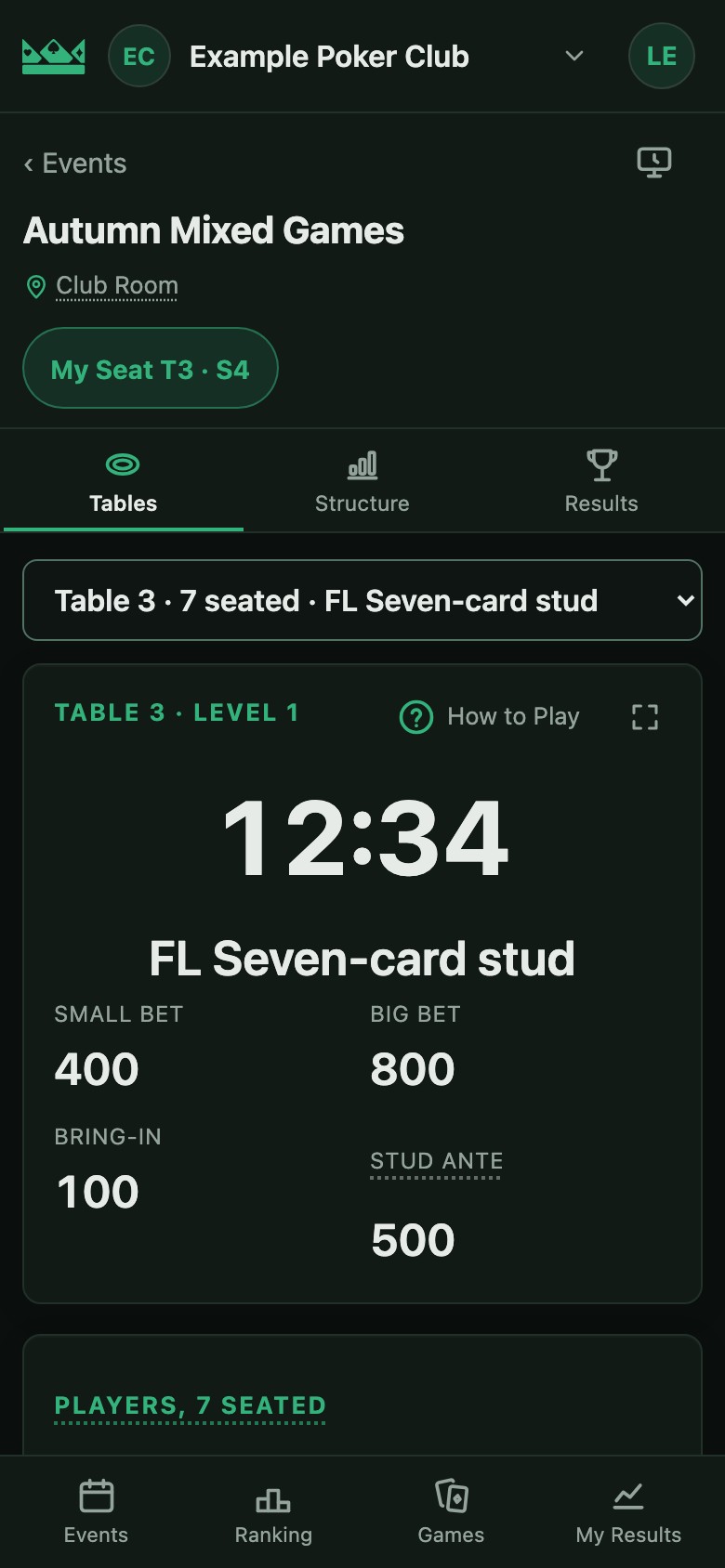 A phone held upright at the event: the player’s seat, the time left and the game at their table.